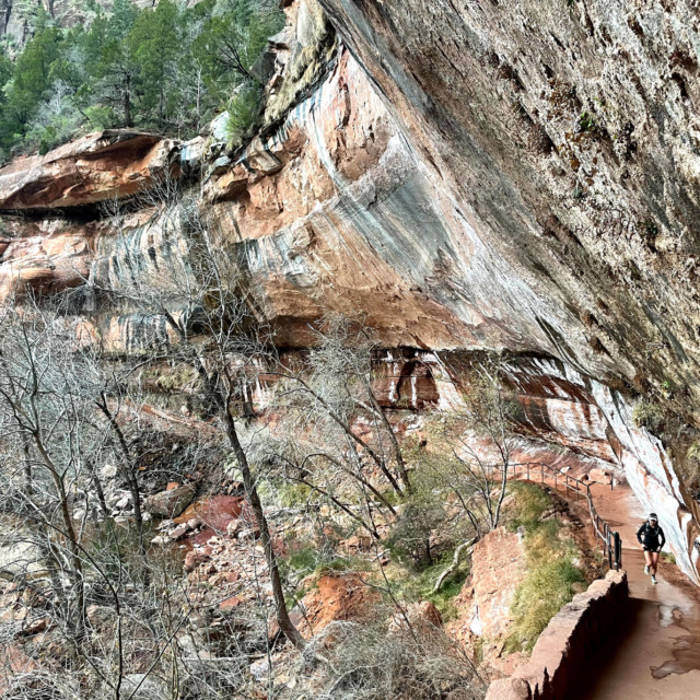 Jayna runs up the paved trail under the Emerald Pools "waterfall."